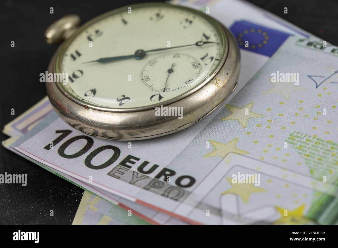 Zeit ist Geld. Taschenuhr und Geld. Stockfoto