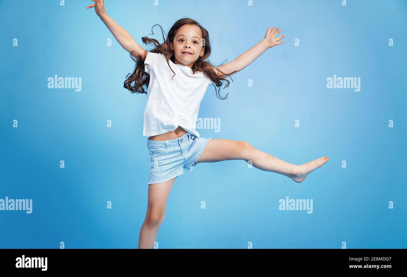 Fröhliche, niedliche Kind springen in einem blauen Raum Stockfoto