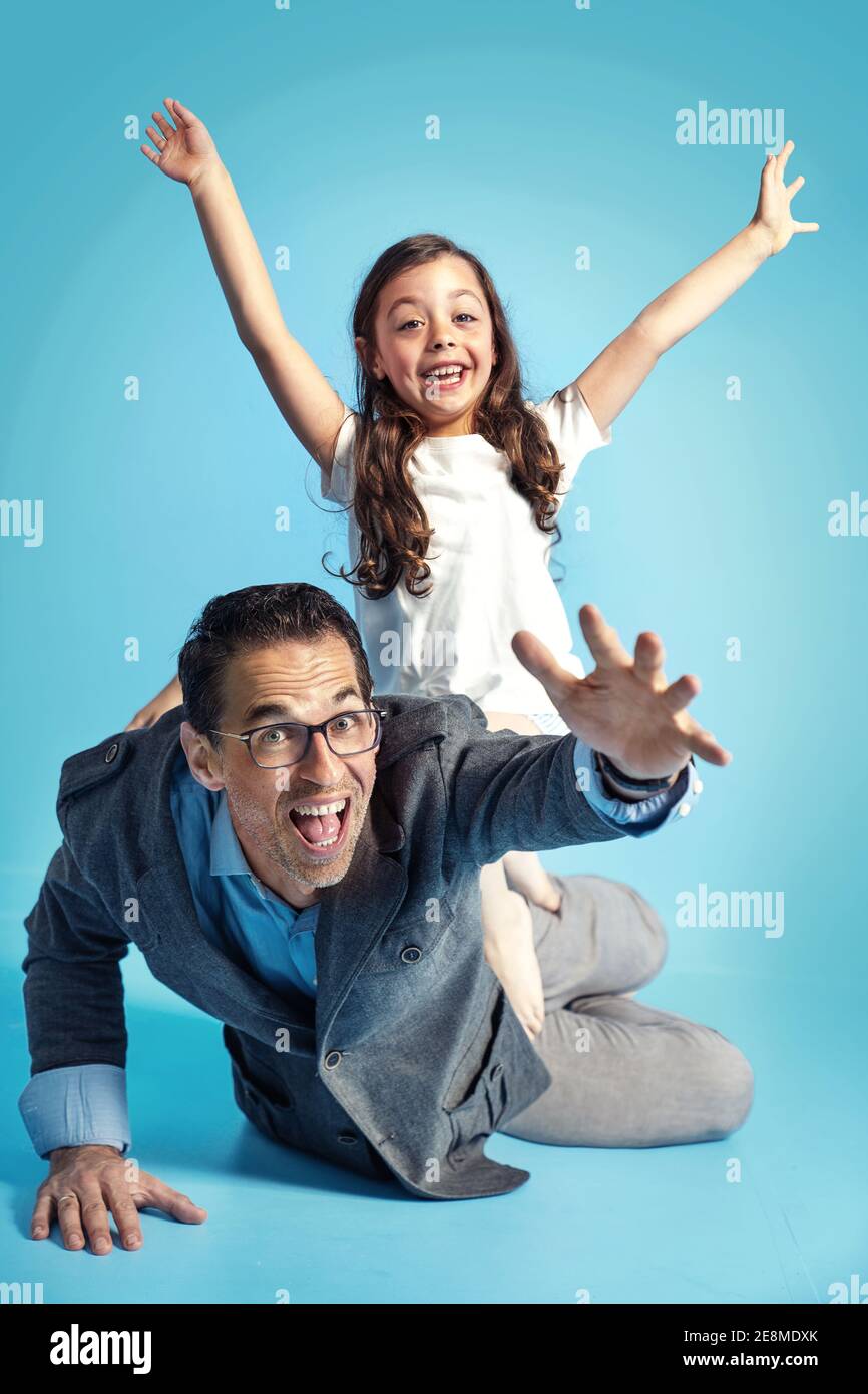 Portrait eines Vaters, der mit einer niedlichen kleinen Tochter posiert Stockfoto