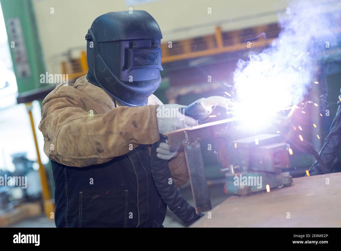 Arbeiter in Schutzmaske mit Gasbrenner machen große Flamme Stockfoto