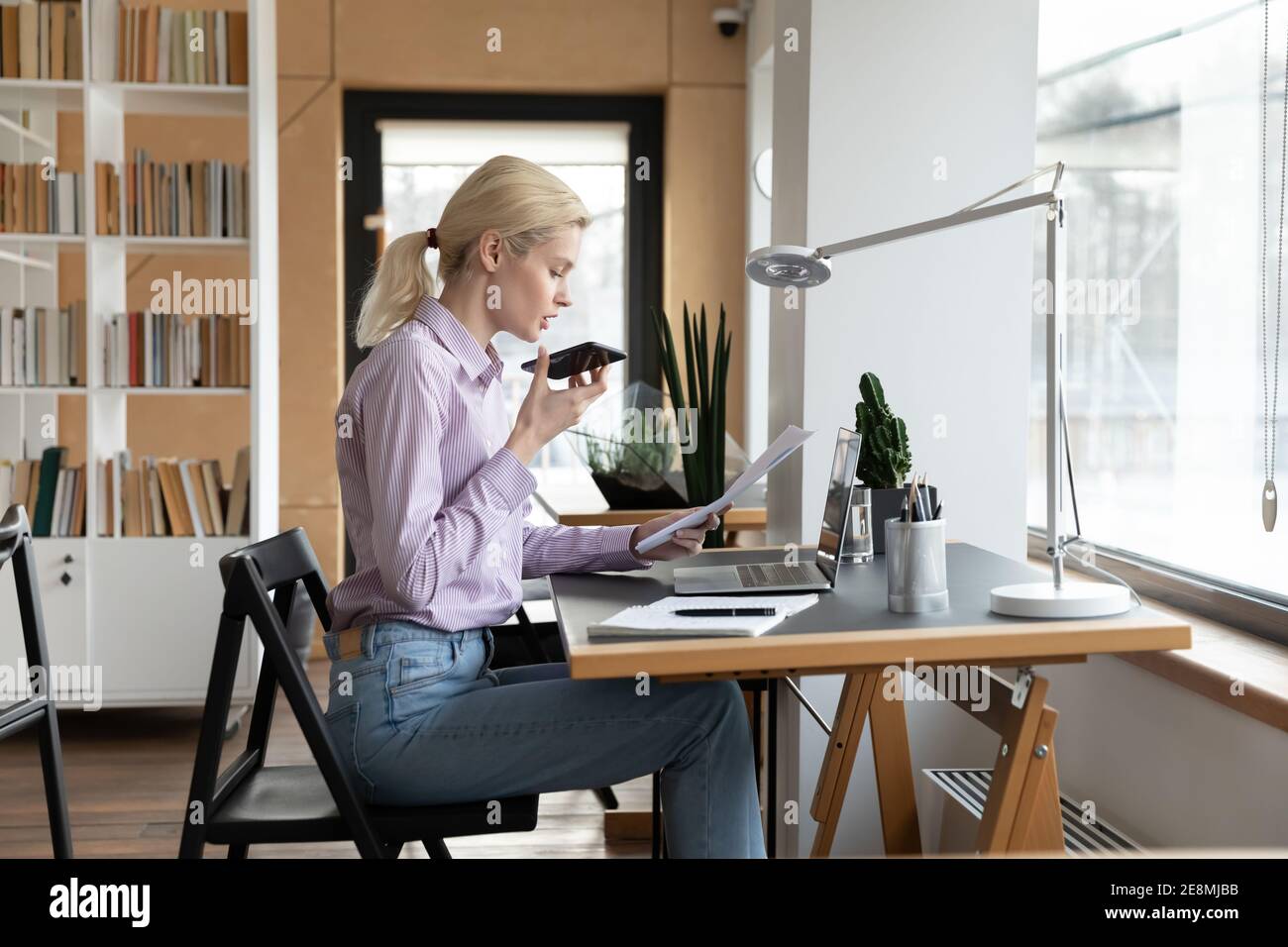 Weibliche Millennial Unternehmer geben Befehl an virtuelle Assistentin Stockfoto