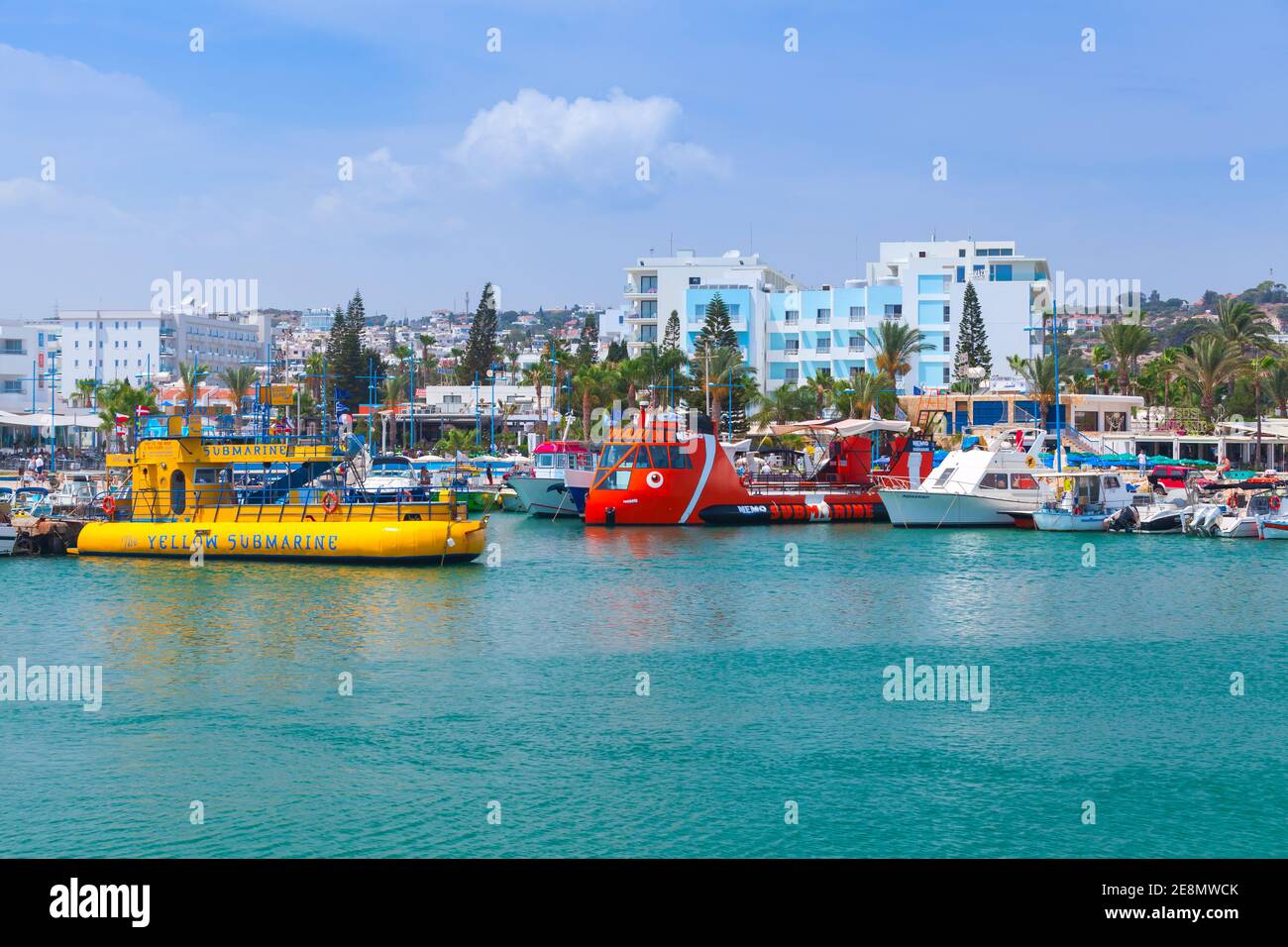 Ayia Napa, Zypern - 12. Juni 2018: Vergnügungsboote, die in Agia Napa festgemacht sind, gehen gewöhnliche Menschen die Küstenstraße entlang. Resort Stadt am äußersten östlichen Ende von Stockfoto
