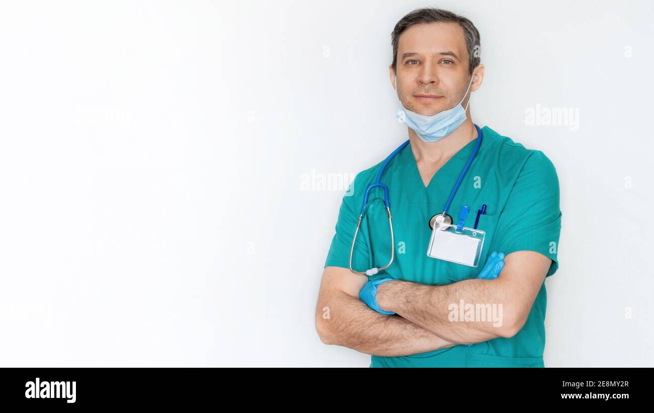 Der Arzt nahm seine Schutzmaske ab und legte sie nach einem harten Tag auf sein Kinn. Kinnmaske. Nahaufnahme des Arztes auf einem weißen Hintergrundbanner. Das Konzept Stockfoto