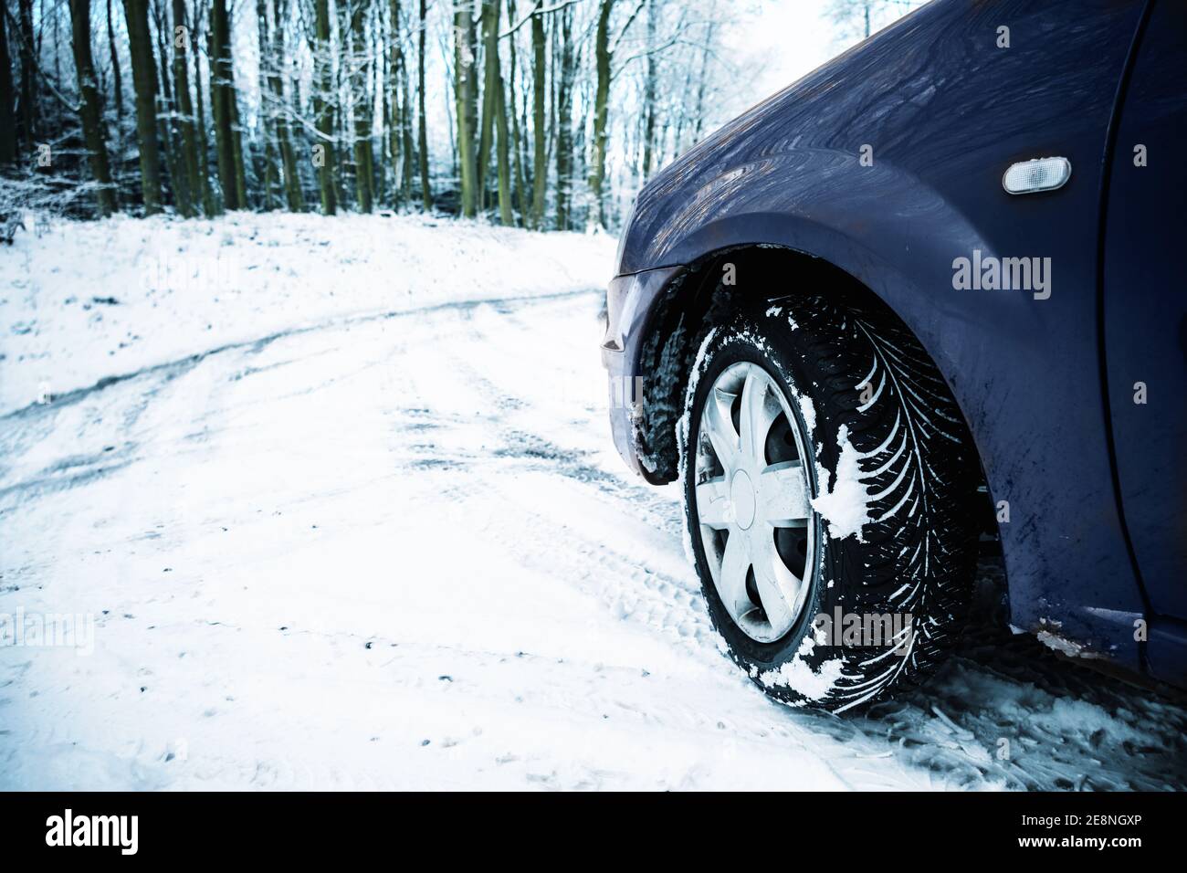 Teil eines Autos auf einer mit Schnee bedeckten Landstraße, Gefahr durch rutschige Bedingungen beim Fahren im Winter, Konzept für den Sicherheitsverkehr, Kopierplatz, s Stockfoto