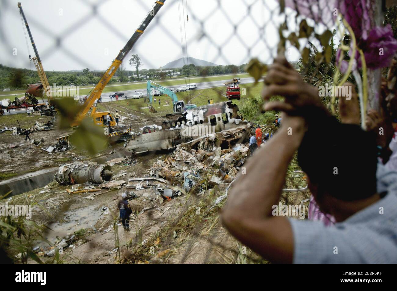 Rettungskräfte begutachten am 17. September 2007 den Flugzeugabsturz auf dem Flughafen von Phuket in Thailand.EIN Billigflugzeug mit 128 Personen an Bord stürzte am 16. September 2007 auf der thailändischen Ferieninsel Phuket ab. 88 Menschen wurden getötet, als es aufbrach und in Flammen aufging, während er versuchte, bei starkem Regen zu landen.die restlichen 42 Menschen an Bord des Fluges aus Bangkok überlebten und wurden in nahe gelegenen Krankenhäusern wegen einer Vielzahl von Verletzungen behandelt. Foto von Patrick Durand/ABACAPRESS.COM Stockfoto