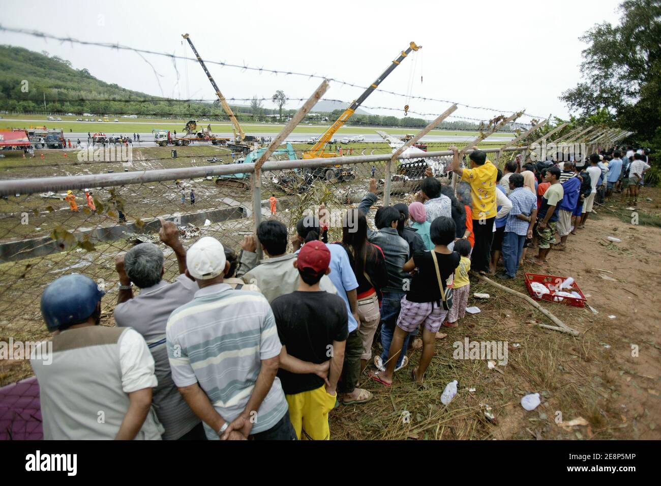 Rettungskräfte begutachten am 17. September 2007 den Flugzeugabsturz auf dem Flughafen von Phuket in Thailand.EIN Billigflugzeug mit 128 Personen an Bord stürzte am 16. September 2007 auf der thailändischen Ferieninsel Phuket ab. 88 Menschen wurden getötet, als es aufbrach und in Flammen aufging, während er versuchte, bei starkem Regen zu landen.die restlichen 42 Menschen an Bord des Fluges aus Bangkok überlebten und wurden in nahe gelegenen Krankenhäusern wegen einer Vielzahl von Verletzungen behandelt. Foto von Patrick Durand/ABACAPRESS.COM Stockfoto