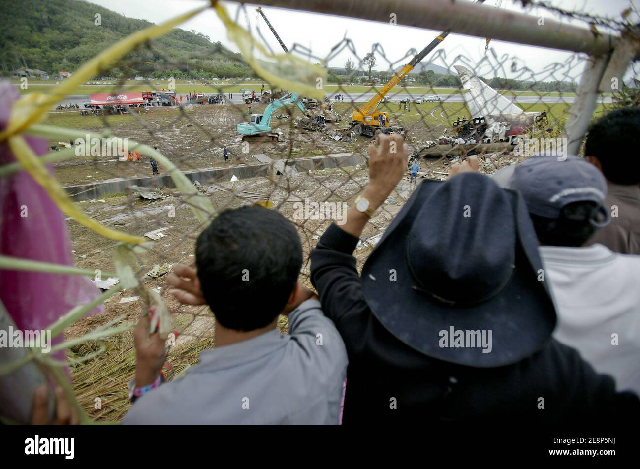 Rettungskräfte begutachten am 17. September 2007 den Flugzeugabsturz auf dem Flughafen von Phuket in Thailand.EIN Billigflugzeug mit 128 Personen an Bord stürzte am 16. September 2007 auf der thailändischen Ferieninsel Phuket ab. 88 Menschen wurden getötet, als es aufbrach und in Flammen aufging, während er versuchte, bei starkem Regen zu landen.die restlichen 42 Menschen an Bord des Fluges aus Bangkok überlebten und wurden in nahe gelegenen Krankenhäusern wegen einer Vielzahl von Verletzungen behandelt. Foto von Patrick Durand/ABACAPRESS.COM Stockfoto