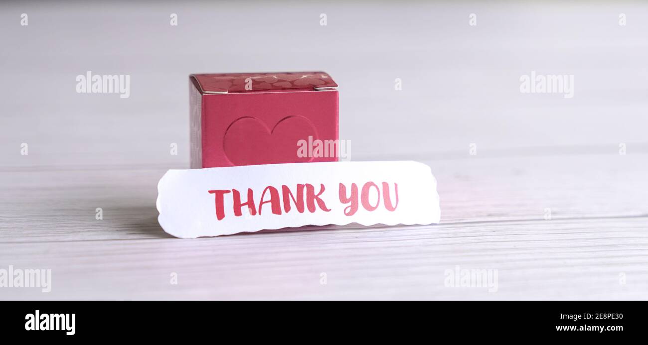 Danksagung vor einer roten Geschenkbox. Ein Ausdruck der Wertschätzung für geliebte Menschen. Stockfoto