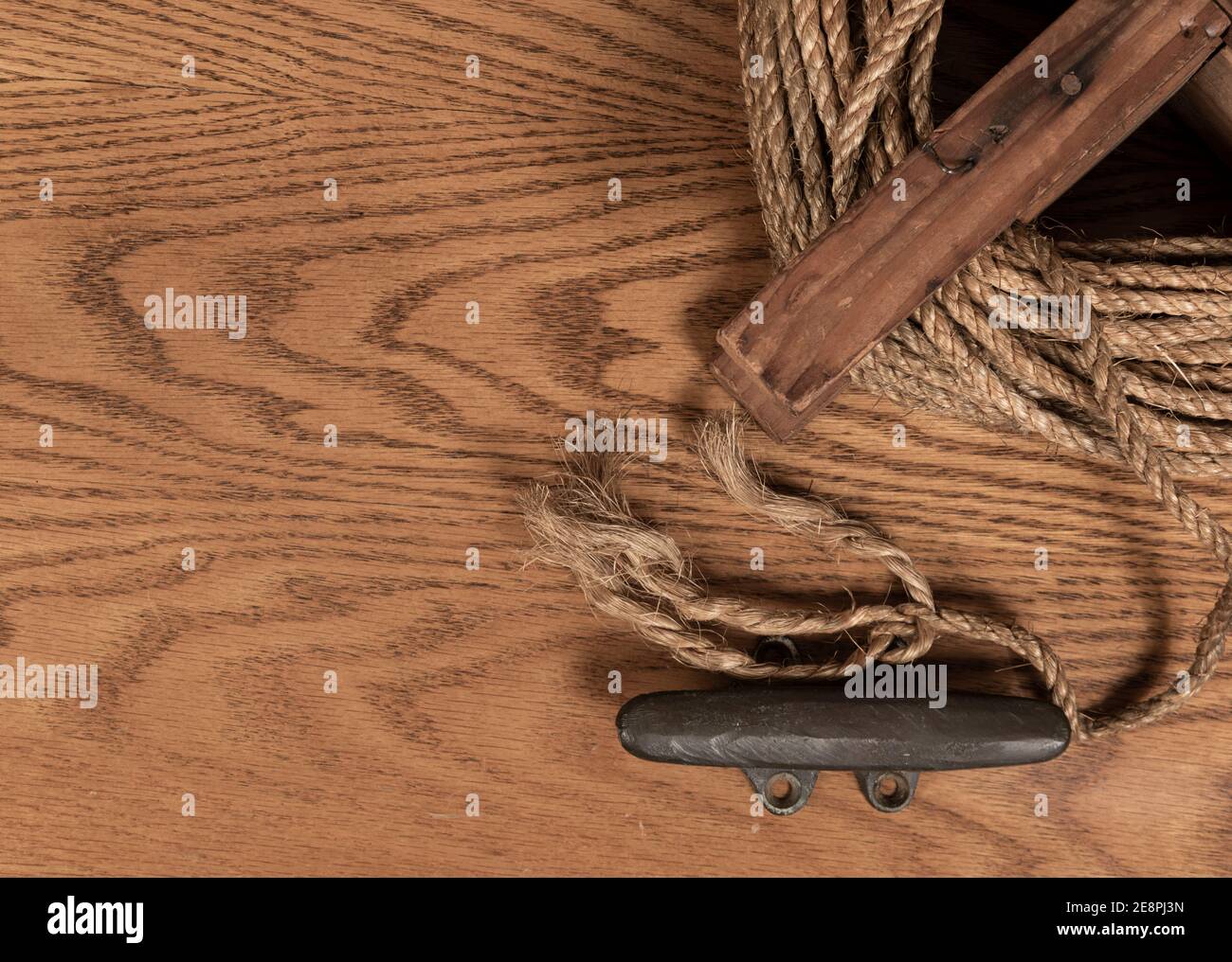 Hintergrund mit vintage Seil Haspel und Stulpe auf einem auf einer hölzernen Oberfläche mit Platz für Text auf der linken Seite angeordnet. Sättigung wurde reduziert. Stockfoto