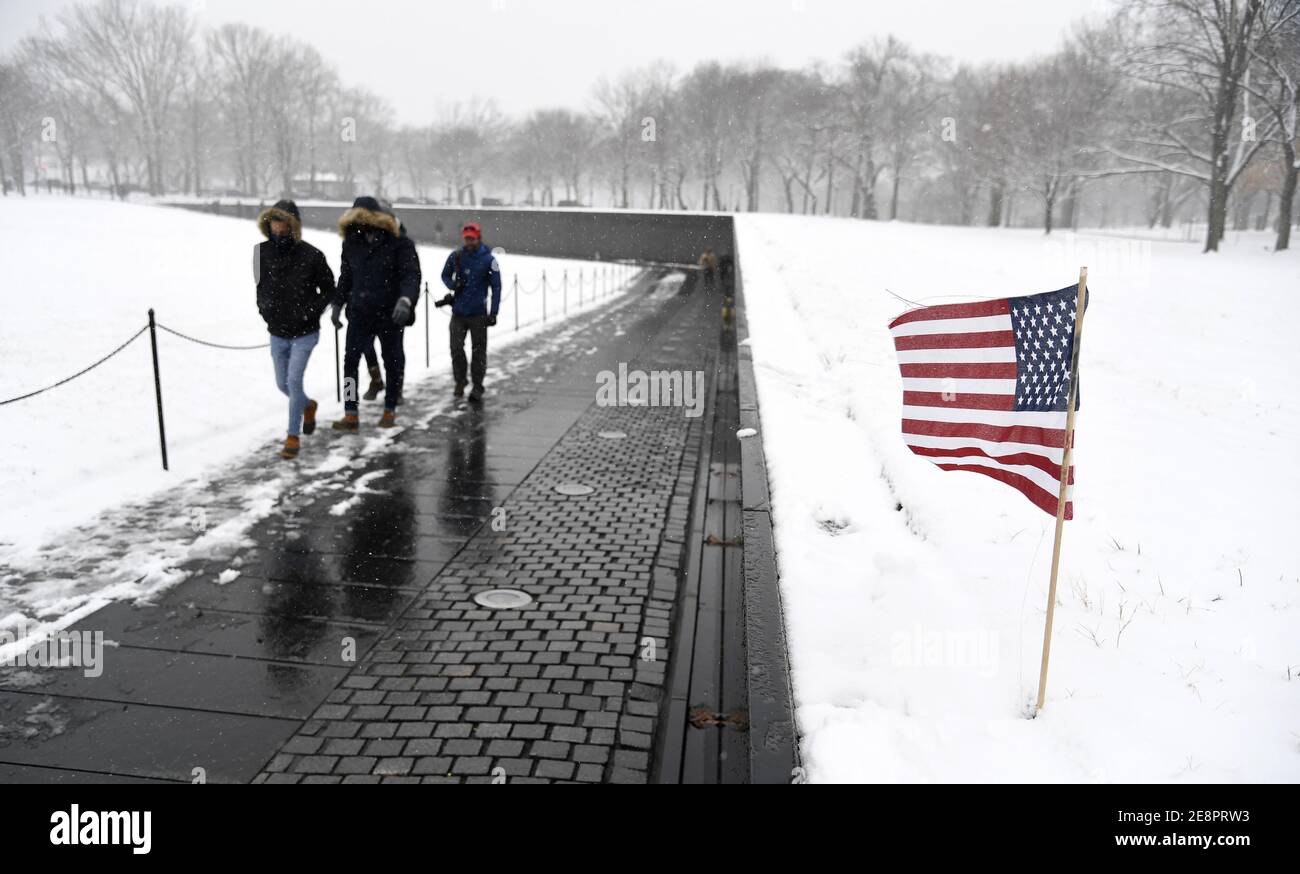 Washington, Usa. Januar 2021. Besucher trotzen dem Wintersturm Orlena, während sie auf dem Gelände des Vietnam Veterans Memorial am Sonntag, 31. Januar 2021, in Washington, DC, spazieren. Der Sturm zieht die Nordostküste der Vereinigten Staaten mit Schnee, Regen, Schneeregen, vereisten Straßen und Stromausfällen in Schand. Foto von Mike Theiler/UPI Kredit: UPI/Alamy Live Nachrichten Stockfoto