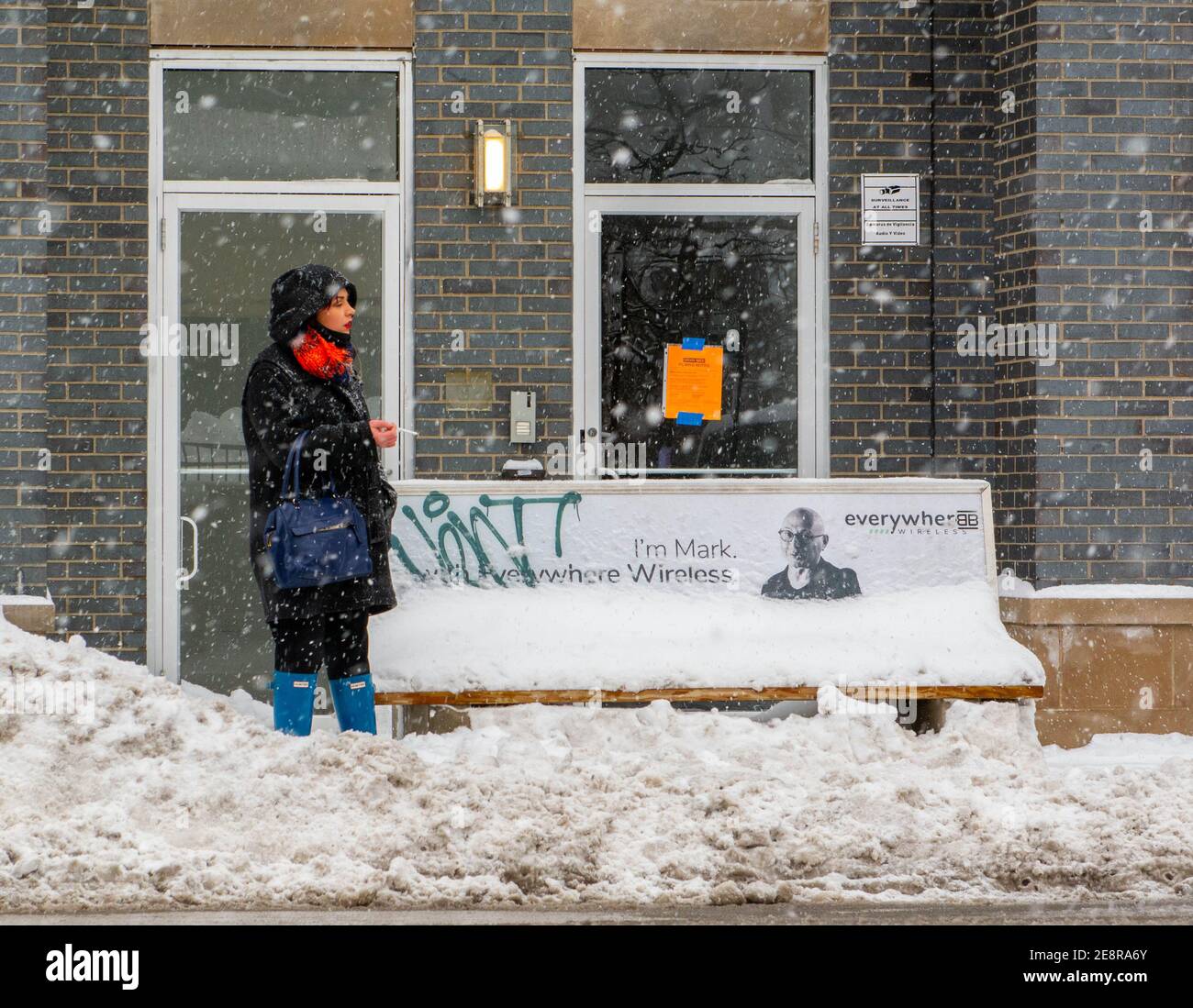 Chicago, IL, USA. Januar 2021. Eine Frau raucht eine Zigarette, während sie während eines Schneesturms in Chicago auf den Bus wartet, 31. Januar 2021. Kredit: Dominic Gwinn/ZUMA Wire/Alamy Live Nachrichten Stockfoto