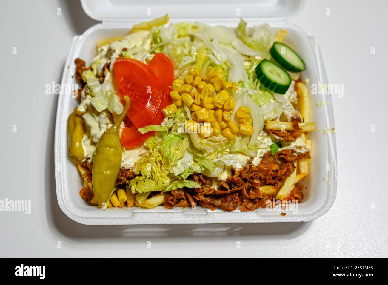 Junk Food in Plastikbox auf dem Tisch Stockfoto