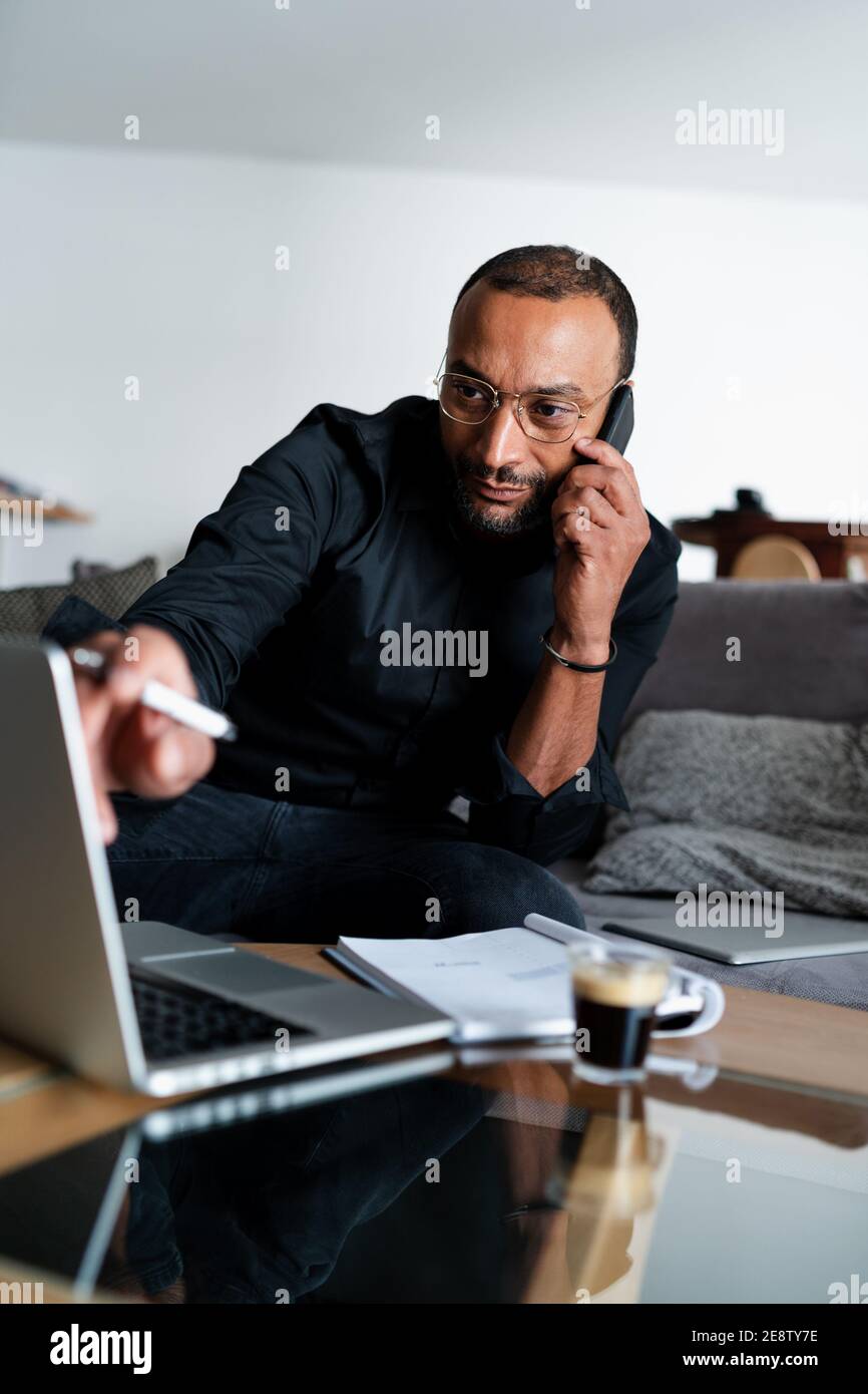 Schöner Unternehmer, der zu Hause Konten verwaltet Stockfoto