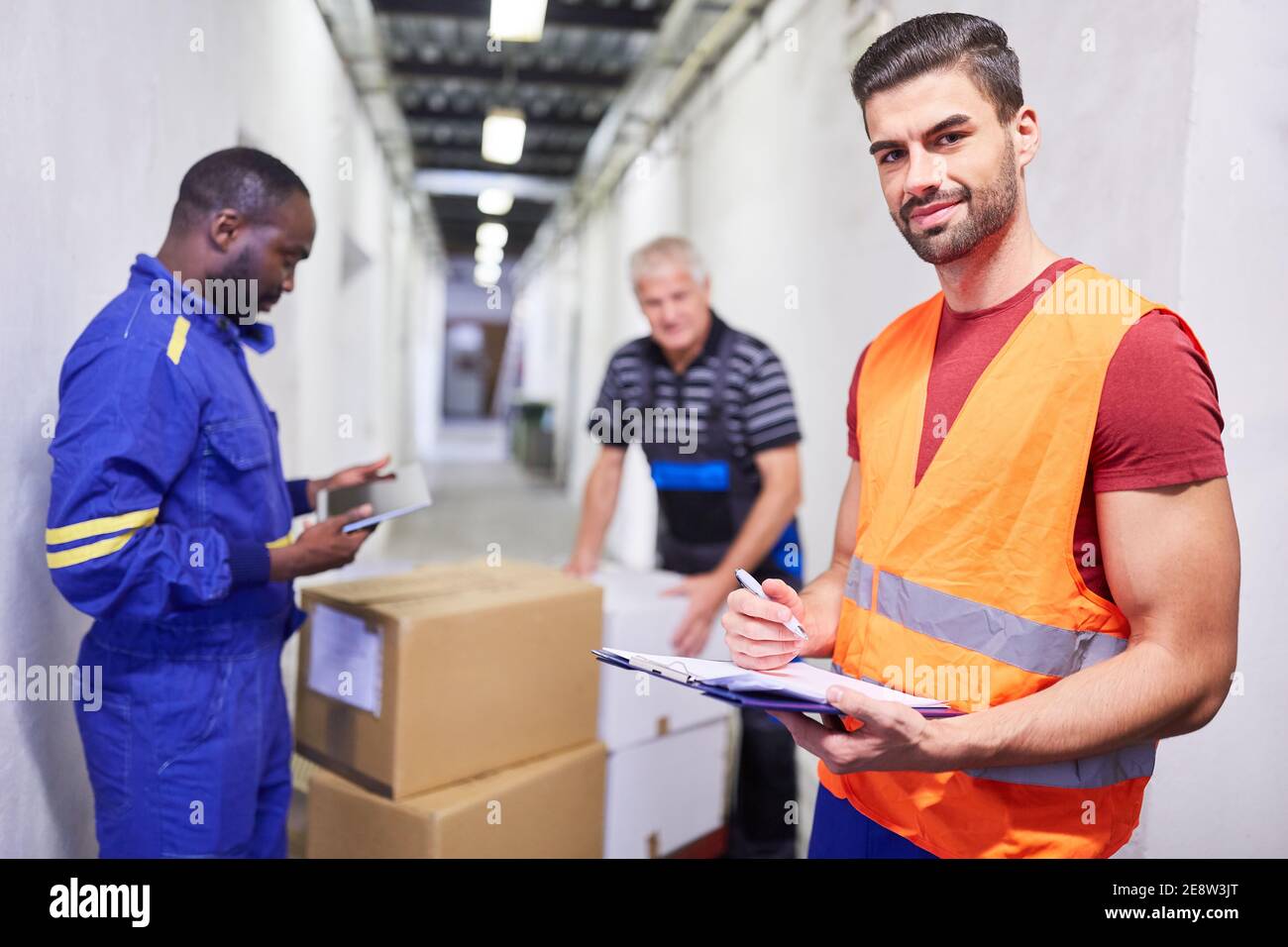 Wareneingangsmitarbeiter prüft Warenanlieferung mit Checkliste auf Zwischenablage Stockfoto