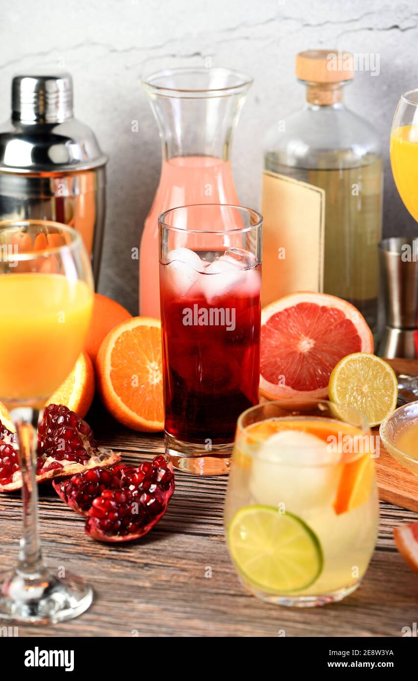 Gin Cocktail Granatapfel auf einem Tisch zwischen Zitrusfrüchten und Getränken. Stockfoto