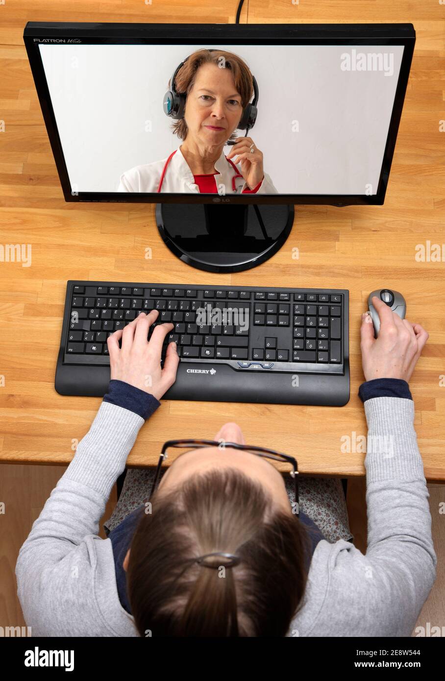 Symbolisches Bild der Telemedizin, Patient spricht mit einem Arzt in einer Videokonferenz, von zu Hause, Stockfoto