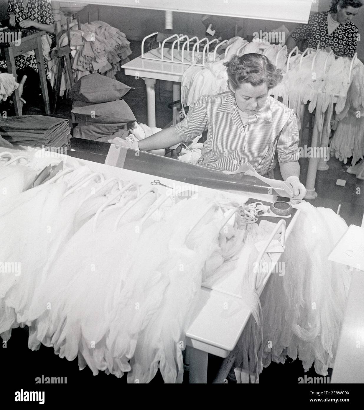 Nylonstrümpfe in den 1950er Jahren. Malmö strumpffabrik Schweden. Gegründet 1926 und wurde der führende Hersteller von Seidenstrümpfen in schweden. Zu diesem Zeitpunkt 1951 hatte das Unternehmen in neue Maschinen investiert, um die beliebten Nylonstrümpfe zu machen. Abgebildet Gullan Åkerman, der überprüft, dass der neu produzierte Nylonstrumpf fehlerfrei ist. 1951 Ref. BE19-11 Stockfoto