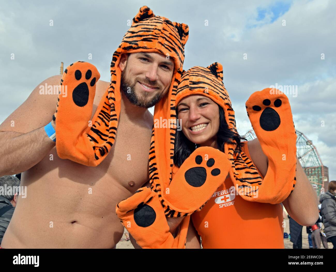 Vor dem Eisbären Club Neujahr schwimmen, ein Paar posiert in passenden bengalen Streifen Kombination Hut Schal & Handschuhe. In Coney Island, Brooklyn, NY. Stockfoto