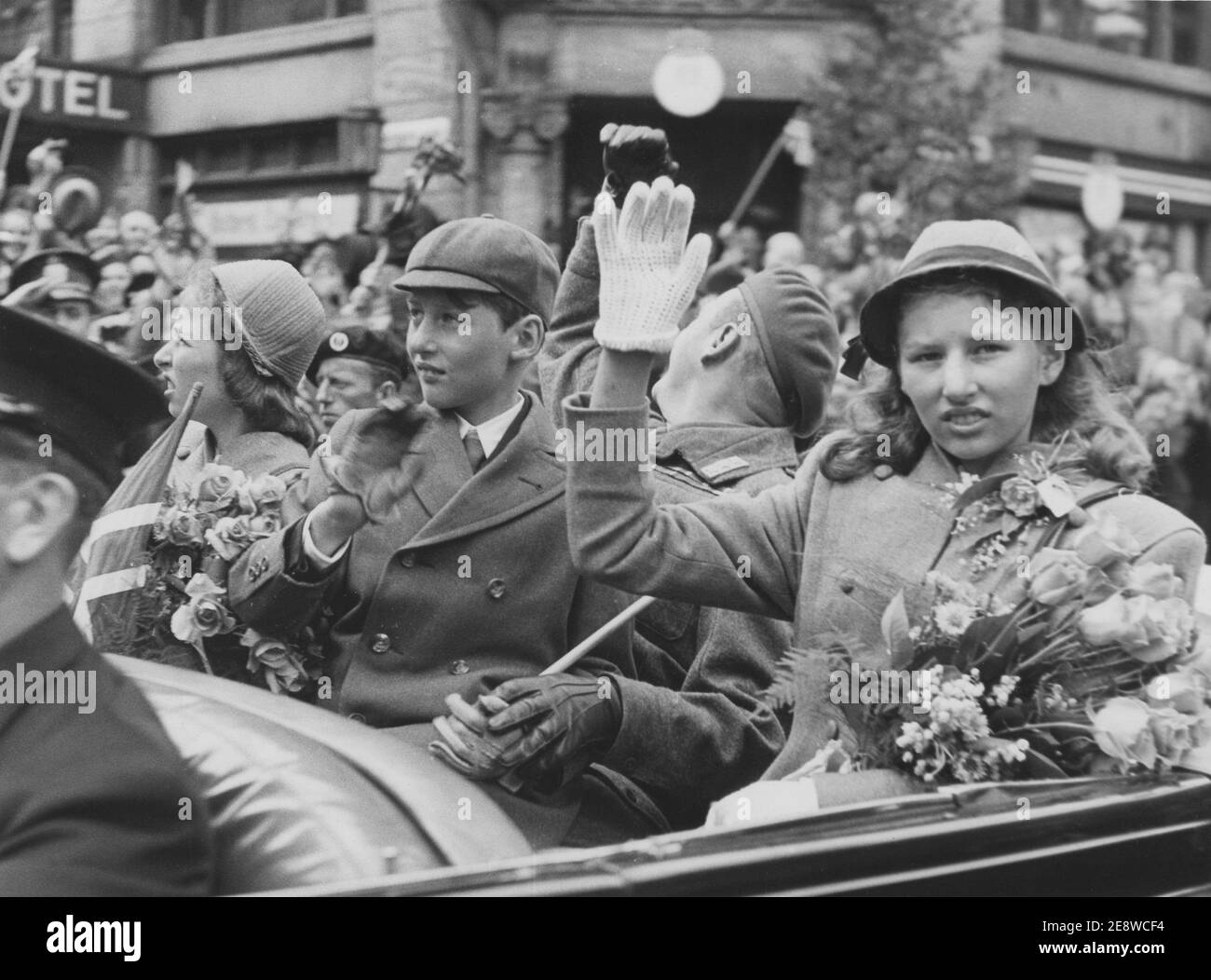 Norwegische Königsfamilie. Hier 1945 bei der Rückkehr nach Norwegen und Oslo, als der zweite Weltkrieg vorüber war. Prinz Harald, seine Schwestern Ragnhild und Astrad und Kronprinz Olav winken in einem Auto den jubelnden Massen in einer Osloer Straße zu. Juni 7 1945 Stockfoto