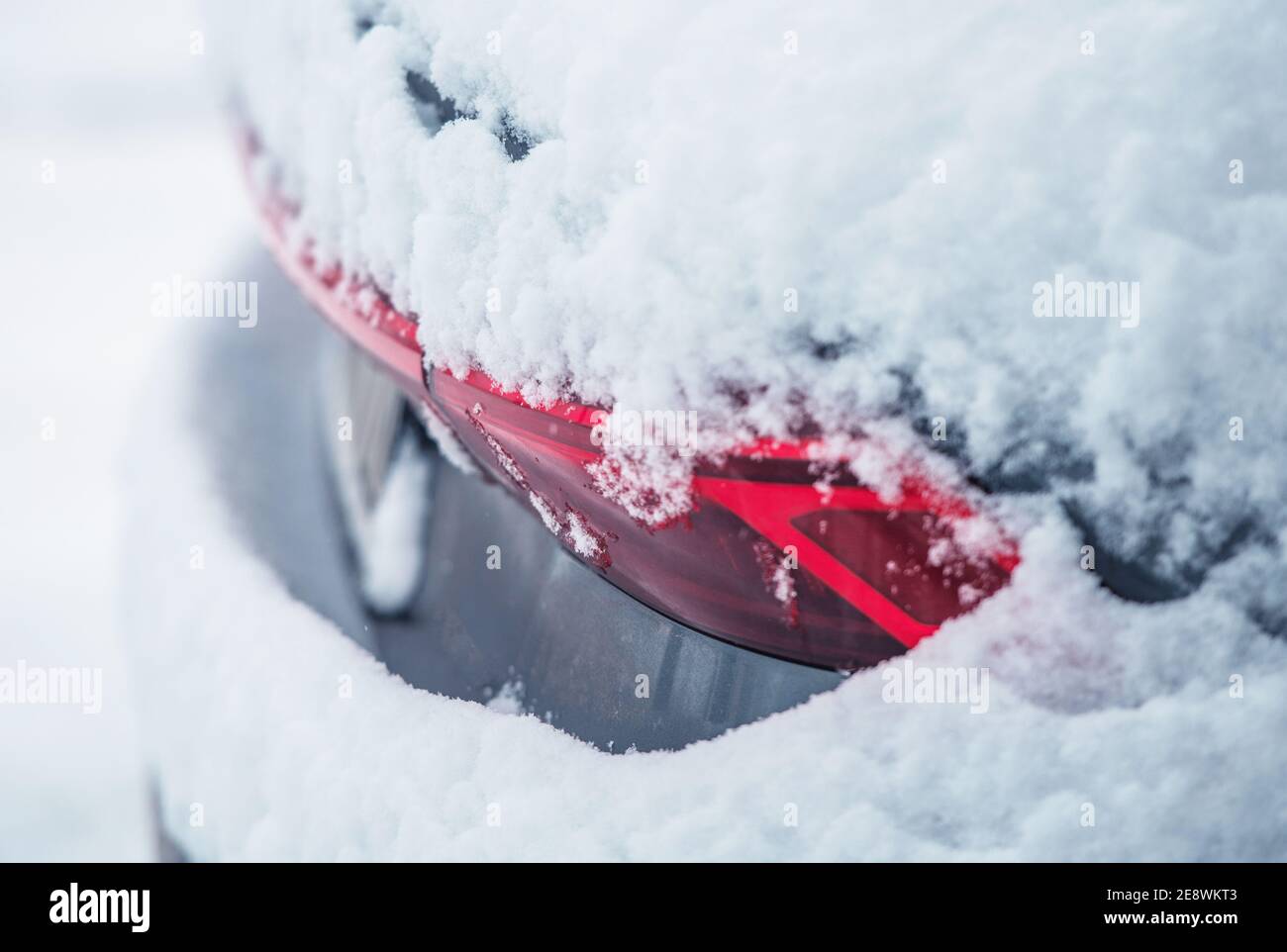 Rückseite des modernen Autos bedeckt von frischem Winterschnee. Nahaufnahme Foto. Automotive Winter Saison Wartung Thema. Stockfoto