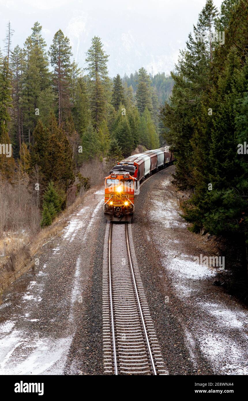 Ein Blick von oben auf eine BNSF-Lokomotive, die von Süden auf die Gleise in Richtung der Stadt Troy, Montana, fährt. Die Lokomotive zieht eine lin Stockfoto