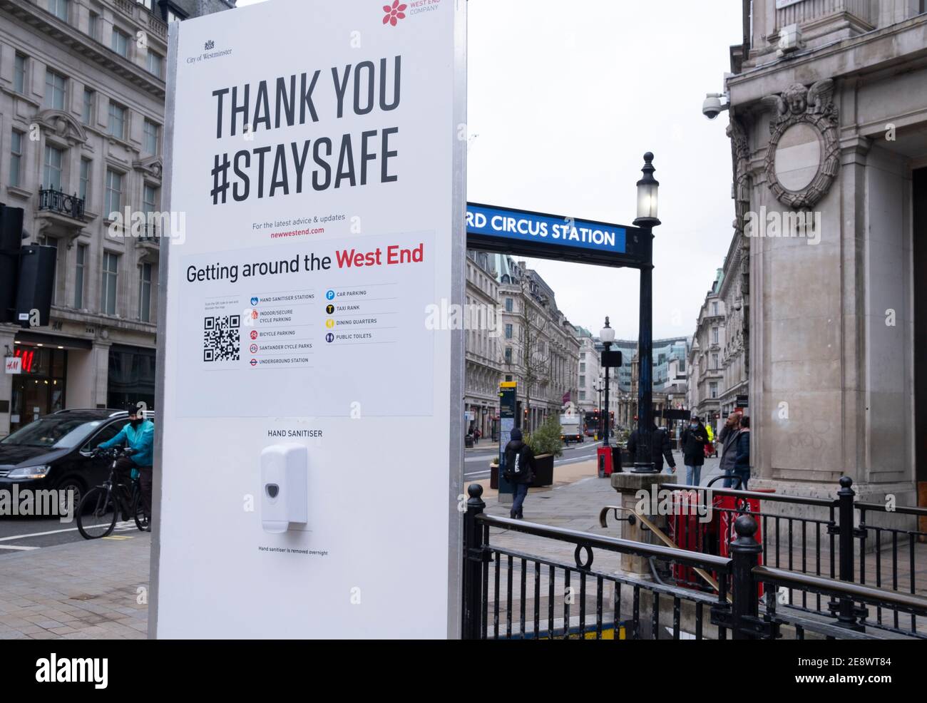 Ein großes Staysafe-Schild mit einem Händedesinfektionsbehälter während der Pandemie im Oxford Circus. London, Großbritannien Stockfoto