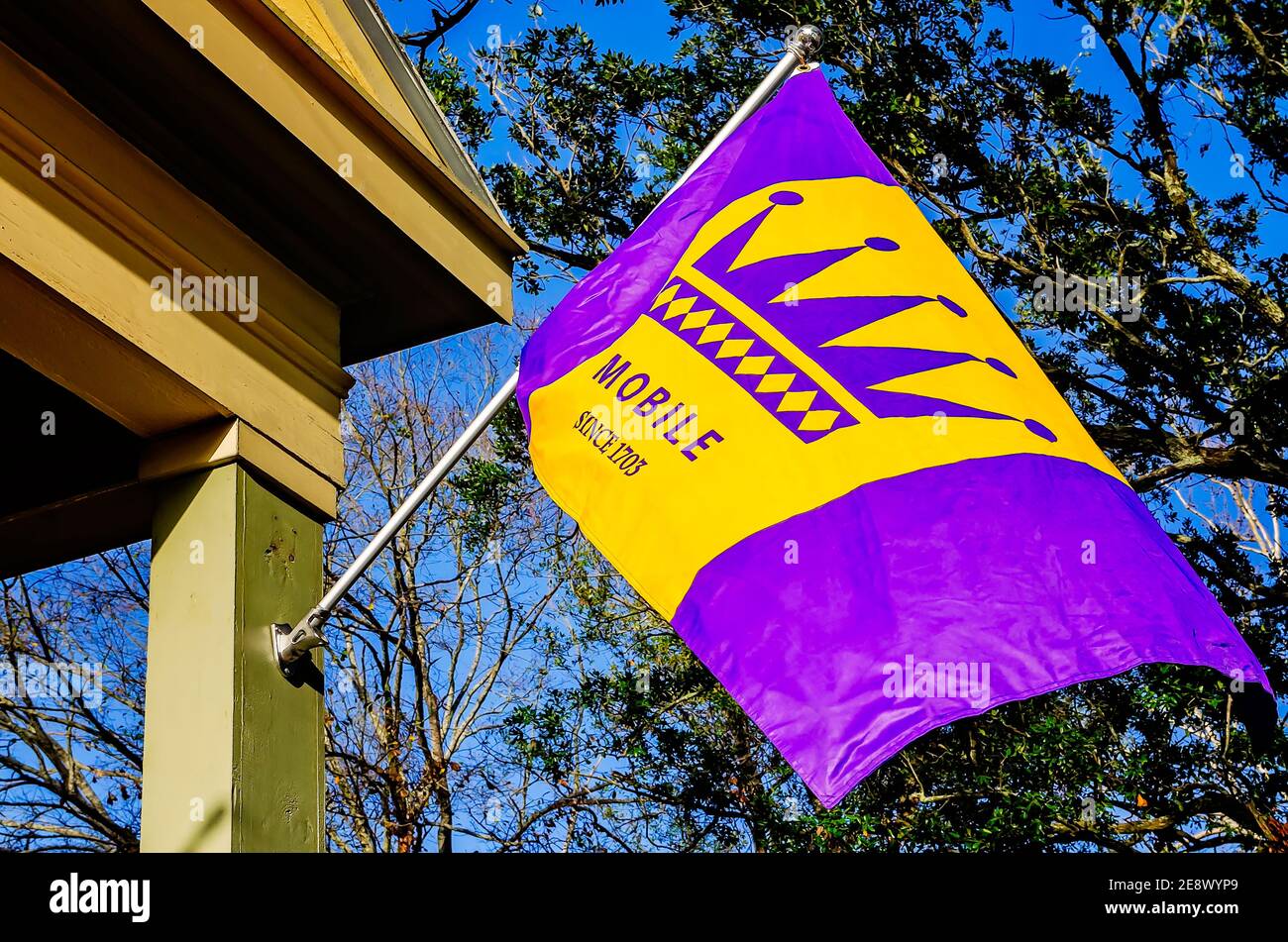 Eine Mardi Gras Fahne in traditionellem Royal Purple und Gold hängt von einem Haus in der Church Street, 31. Januar 2021, in Mobile, Alabama. Stockfoto