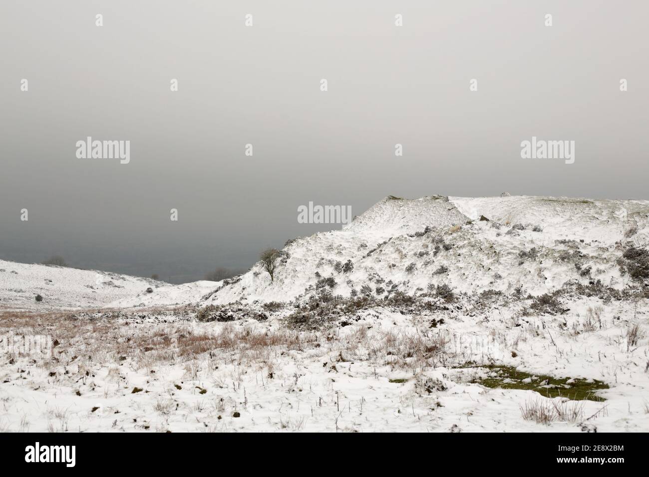 Verschneite Verwurfhaufen im Clee Hill Quarry, Shropshire, England, Großbritannien. Stockfoto