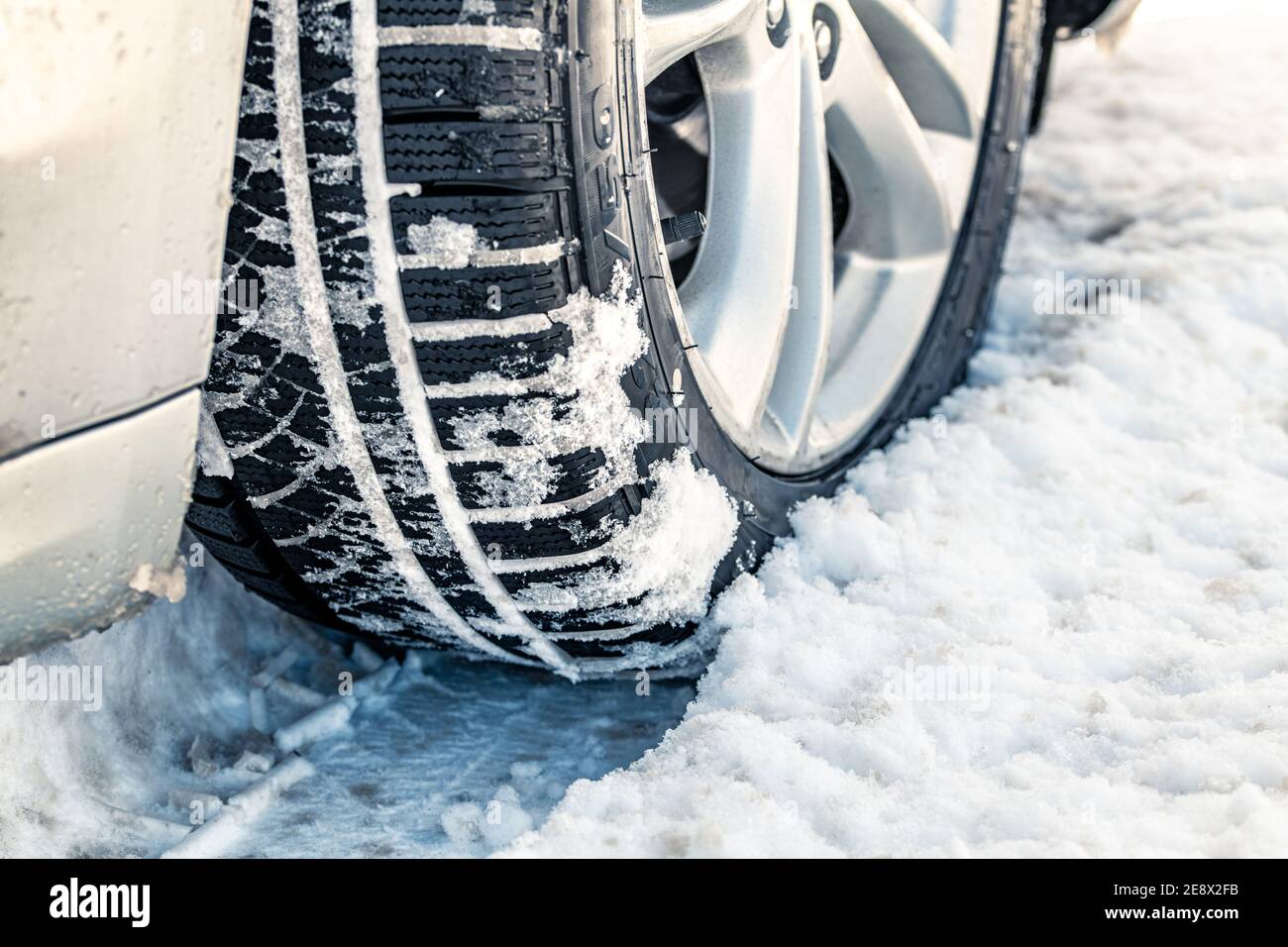 Nahaufnahme der Autoreifen im Winter auf der schneebedeckten Straße. Selektiver Fokus Stockfoto