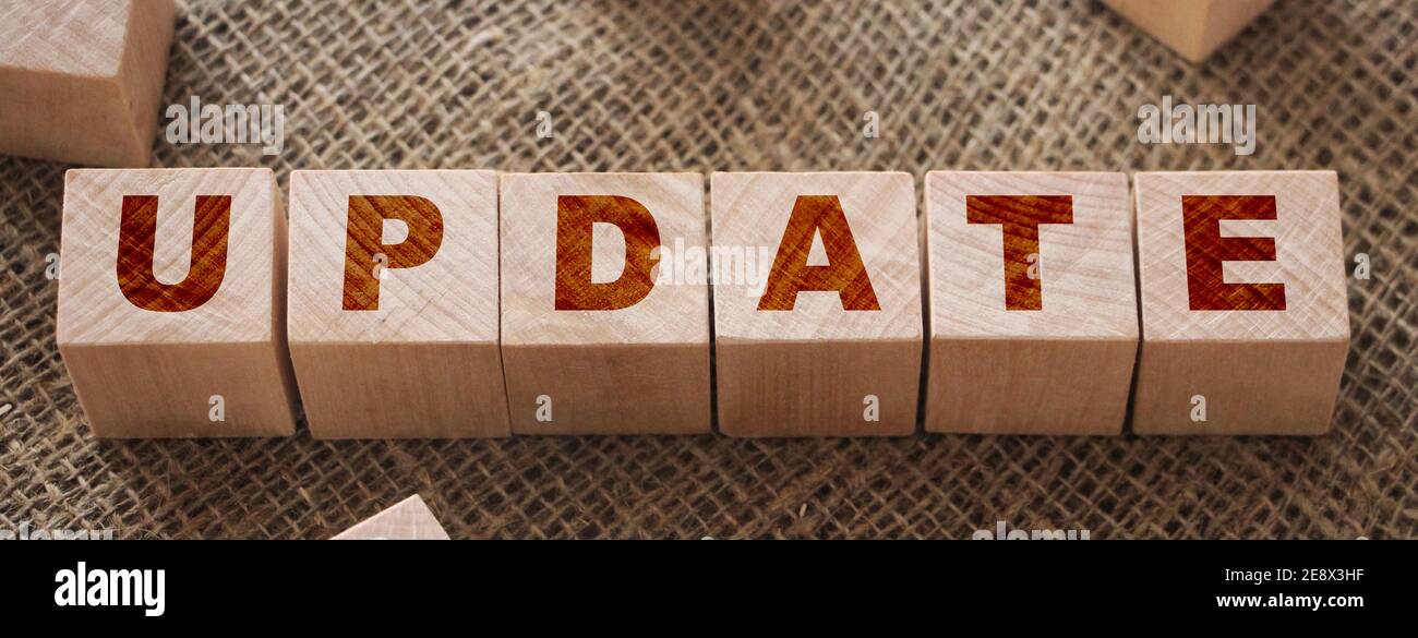Aktualisieren Wort auf einem Holzwürfel auf burlap Leinwand Hintergrund. Business Technologies Fertigungskonzept. Stockfoto