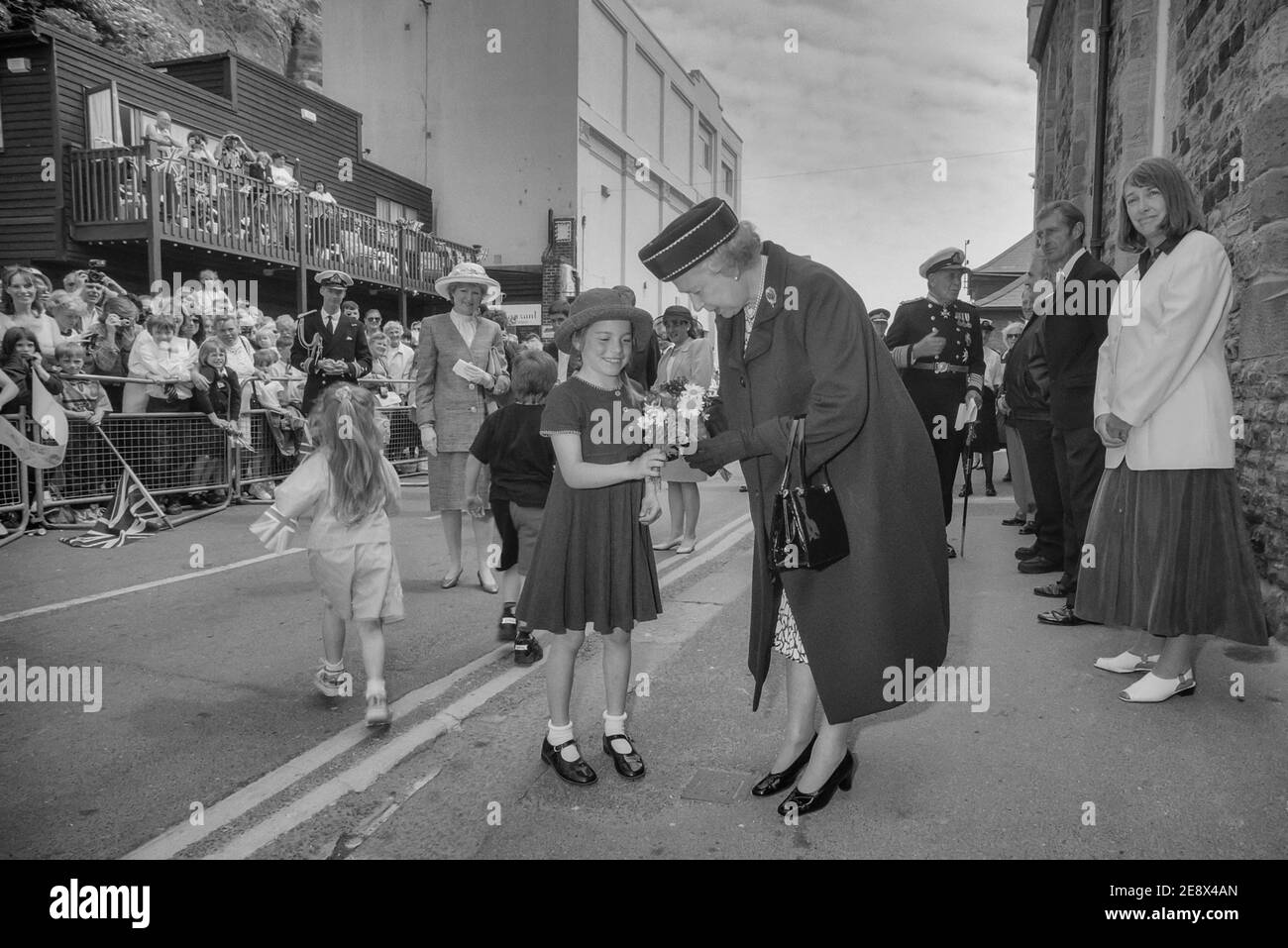 Königin Elizabeth II. Erhält Blumenstrauß von Kindern während ihres Besuches in Hastings Old Town, East Sussex, England, Großbritannien. 6. Juni 1997 Stockfoto