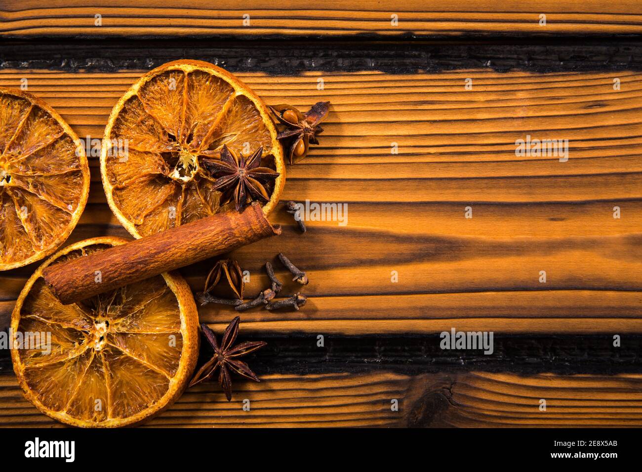 Aromatische Winter Weihnachten Gewürze auf Holz Hintergrund. Zimtstange, Nelke, Sternanis, getrocknete Orangenscheiben leeren Raum für Text. Stockfoto