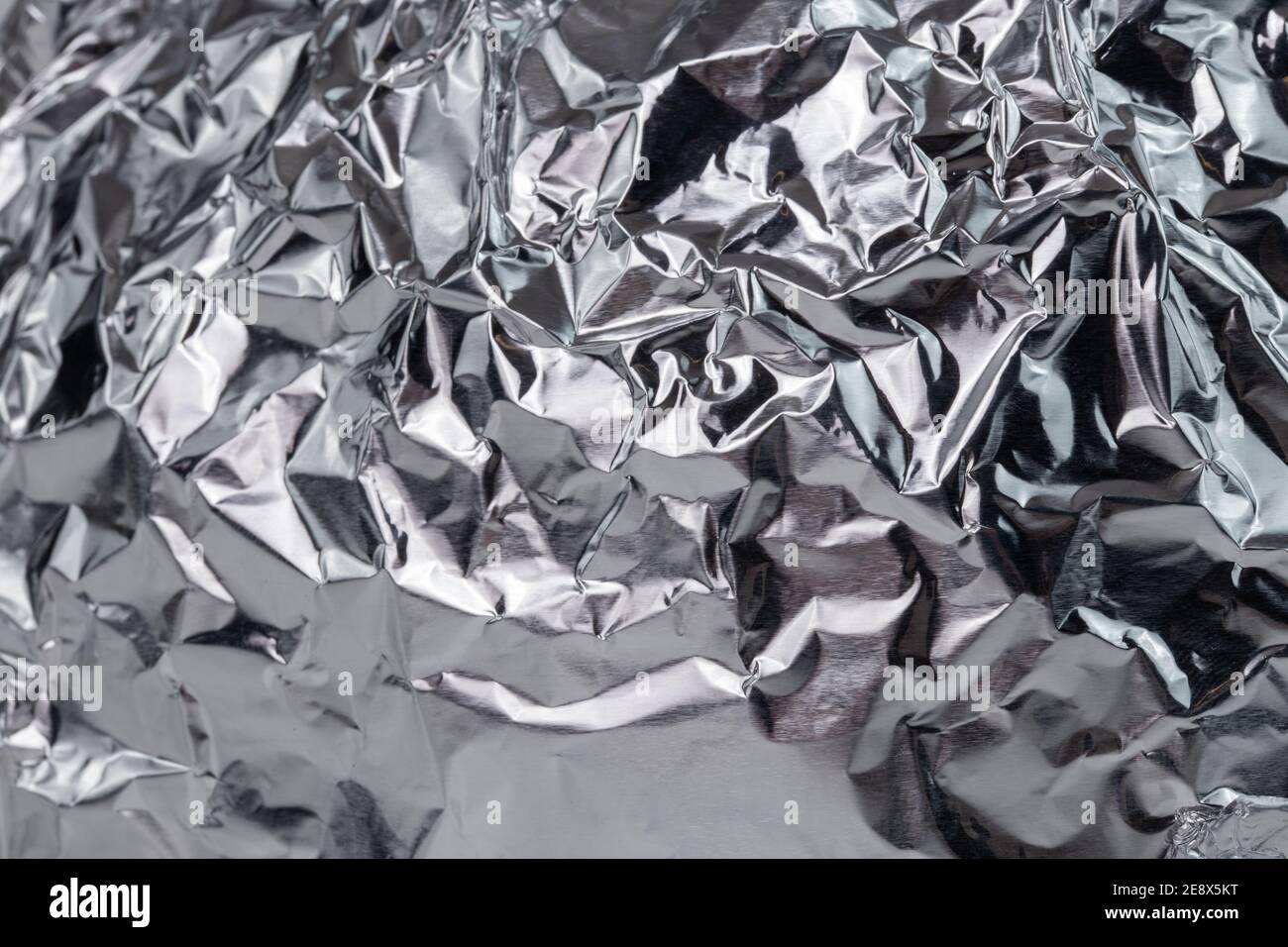Zerknitterte Aluminiumfolie flacher Nahaufnahme Hintergrund mit selektivem Fokus. Stockfoto