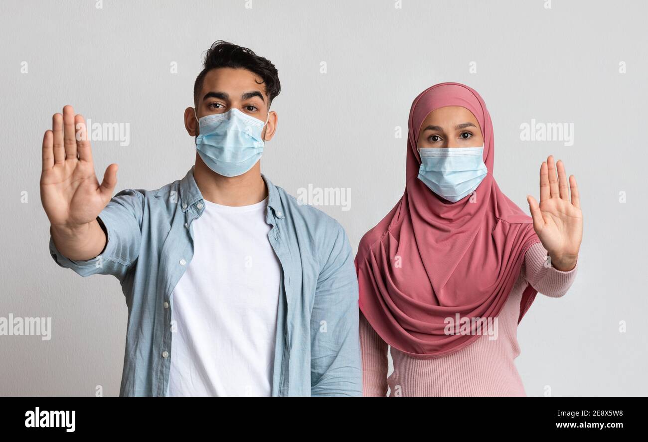 Ernst Muslim Paar In Medizinischen Masken Zeigen Stop Geste Mit Öffnen Sie Die Handflächen Stockfoto