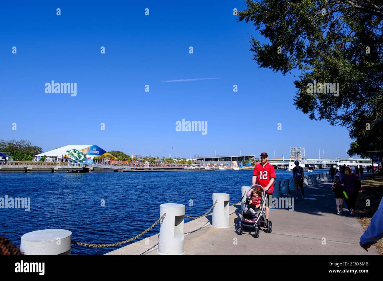 Mann, der den Kinderwagen den Tampa Riverwalk hinunter schiebt - Super Bowl LV (55) Tampa, Florida Stockfoto