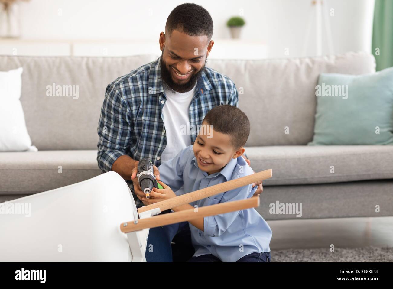 Schwarz Vater Und Sohn Fixing Table Tun Hausarbeiten Zu Hause Stockfoto