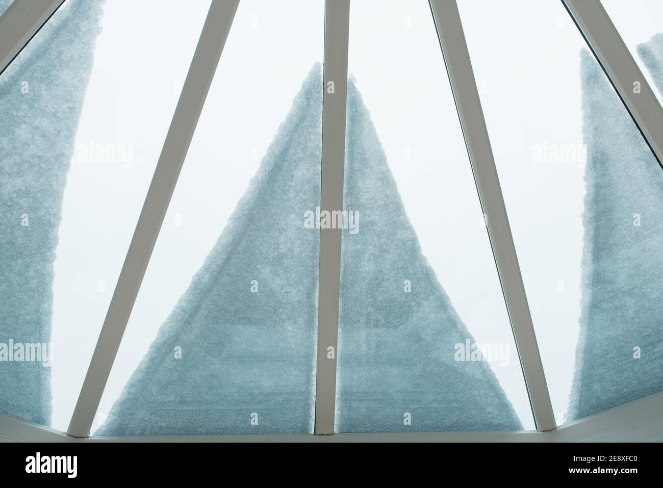 Nahaufnahme des Schnees auf dem Wintergartendach, von innen heraus schauen, Schaffung eines Blütenblatt und linear geformten Muster Stockfoto