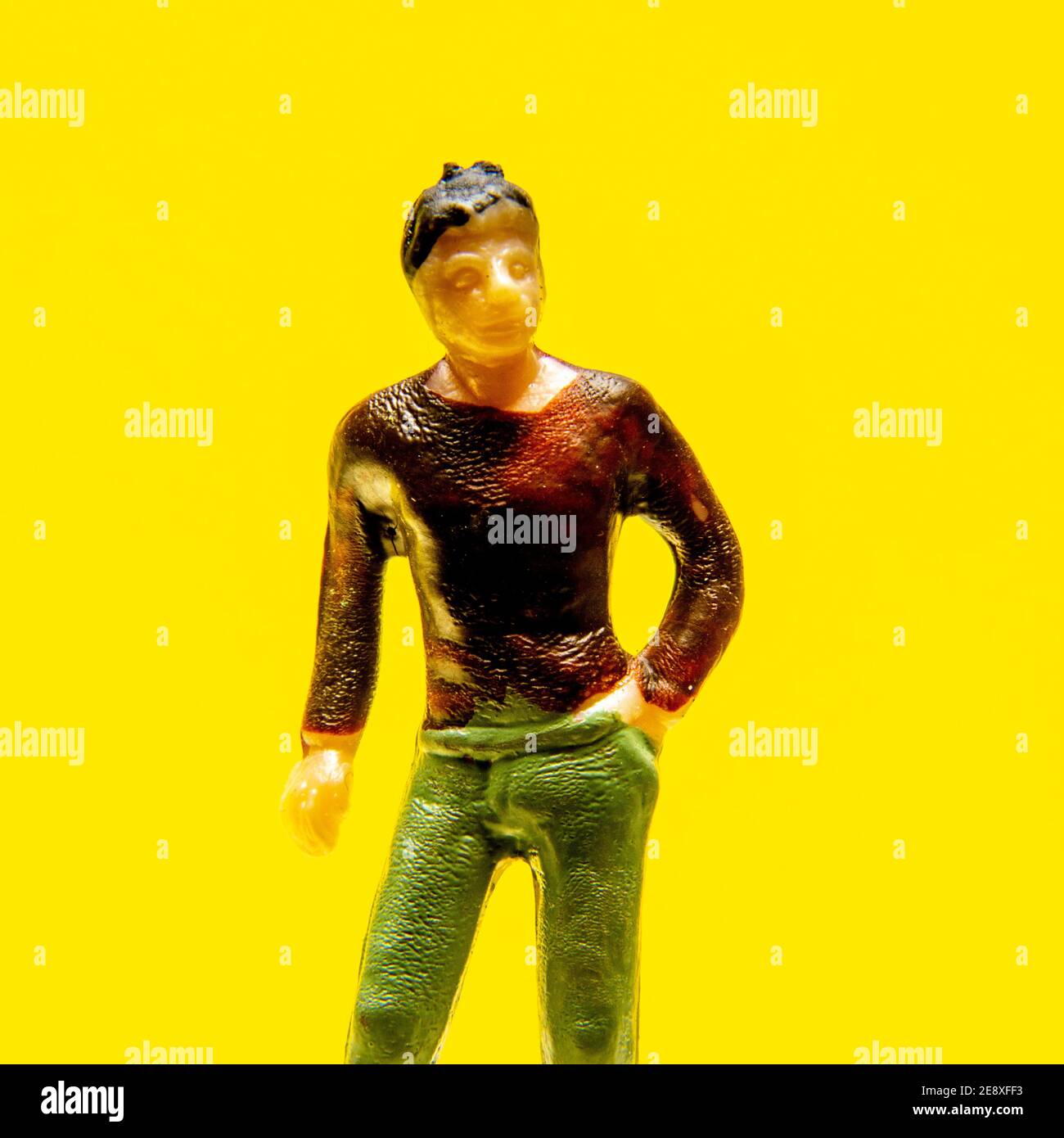 Farbenfrohe Spielzeugfigur auf einem hellgelben Hintergrund, die lebendige Details und ein verspieltes Design hervorhebt Stockfoto