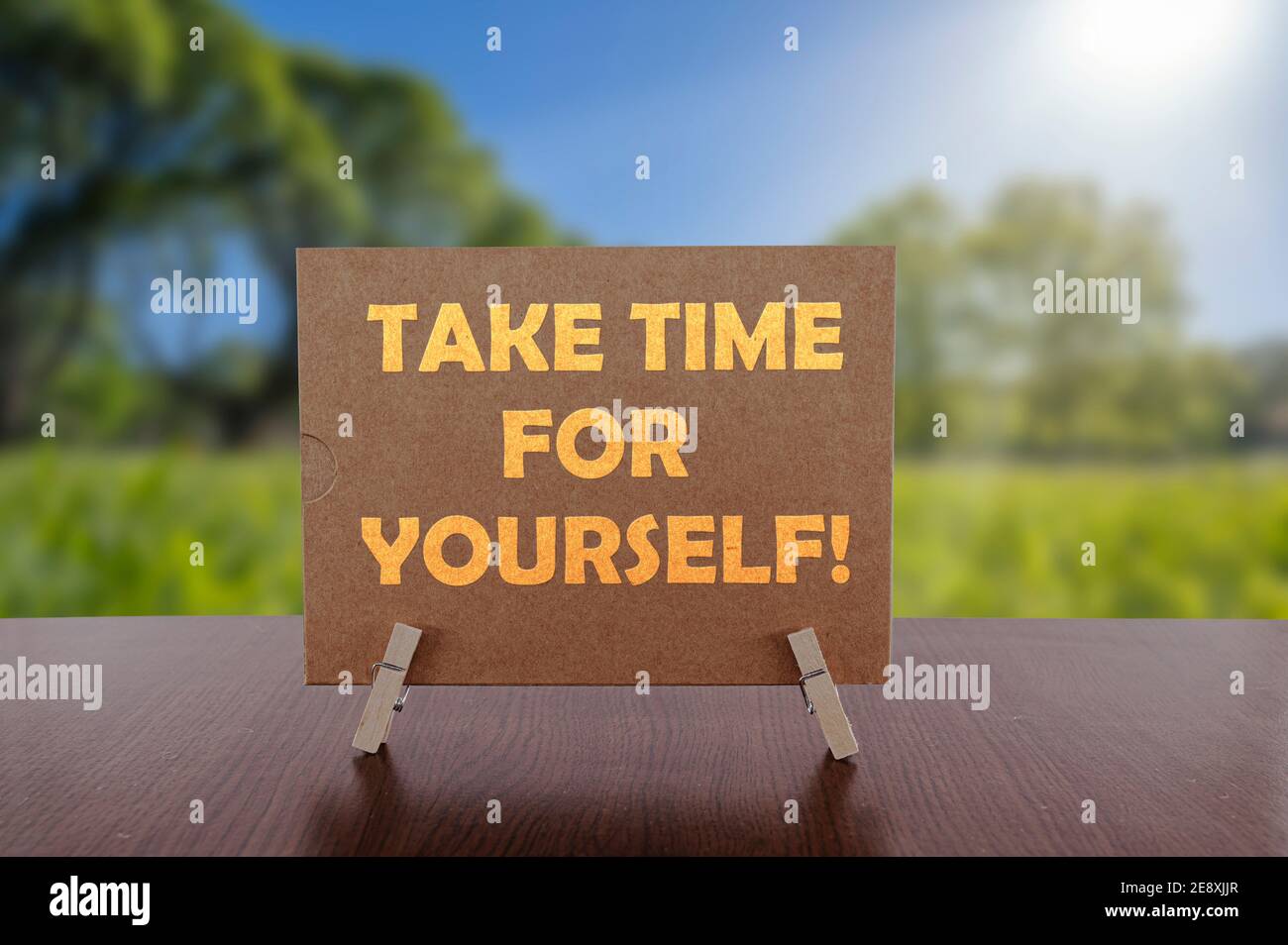 Nehmen Sie sich Zeit für sich Text auf Karte auf dem Tisch mit sonnigen grünen Park Hintergrund. Stockfoto