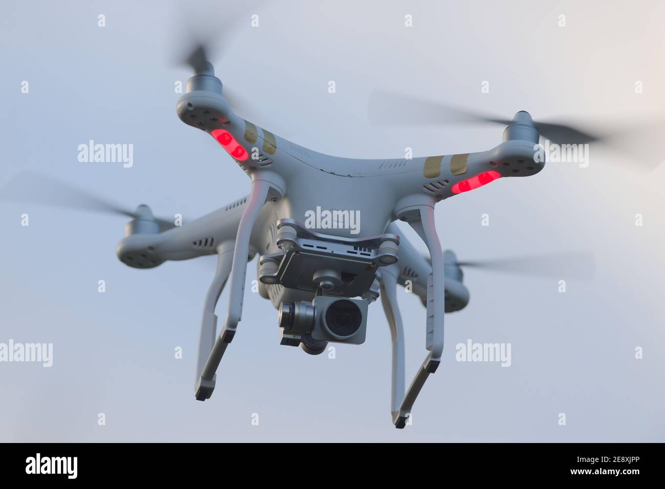 Great Malvern, Großbritannien, 27th. Dezember 2020: Vollformat-Nahaufnahme einer schwebenden Quadcopter-Kamera-Drohne. Einfacher Himmelshintergrund Stockfoto