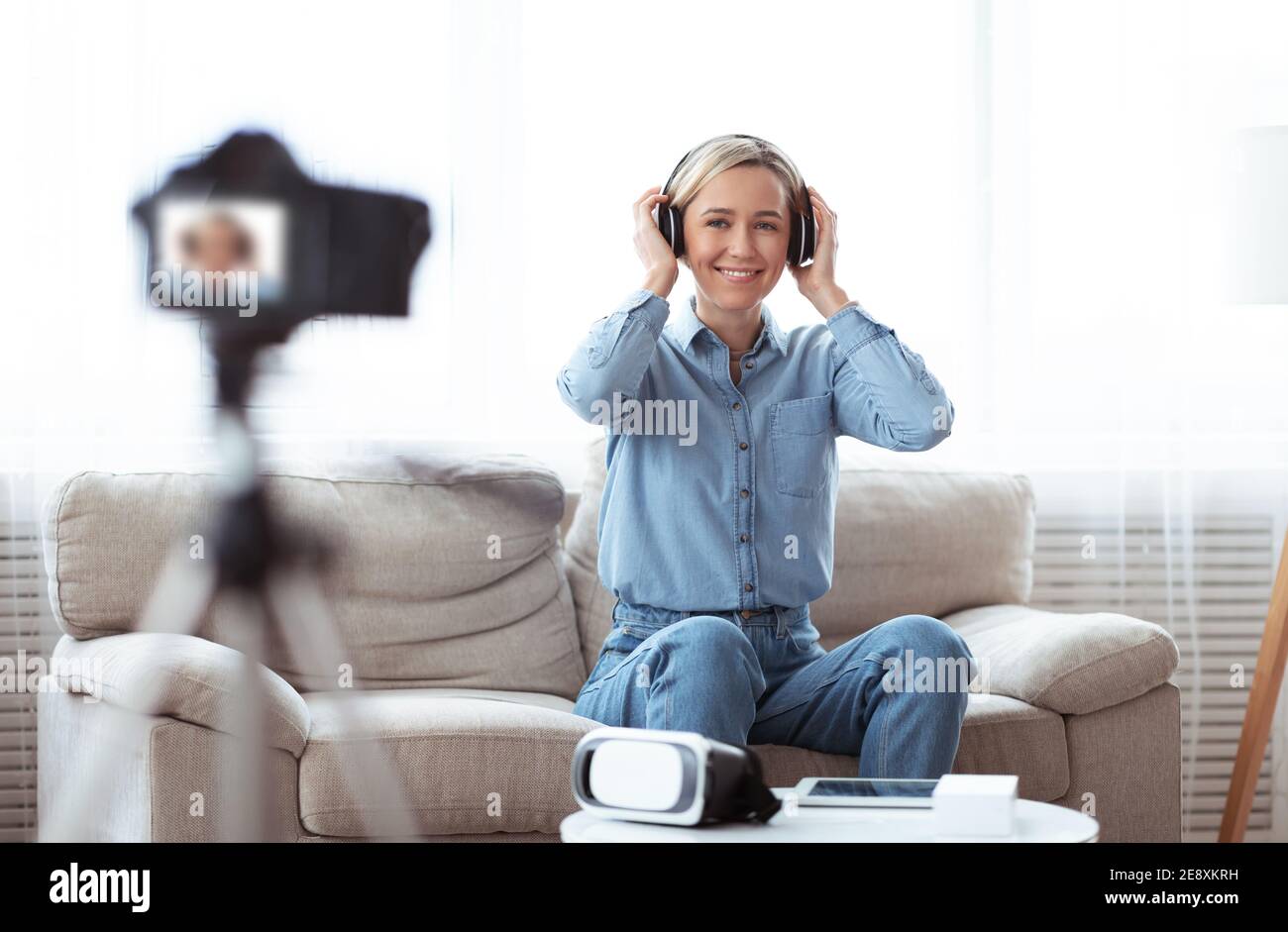 Millennial Bloggerin demonstriert neue Headset, Werbung für moderne Gadget in Video-Review für ihr vlog Stockfoto