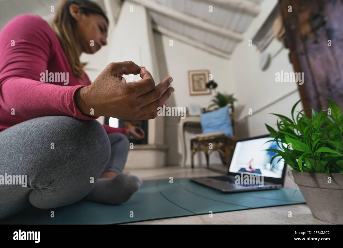 Latein reife Frau tun Yoga virtuelle Fitness-Klasse mit Laptop Zu Hause - E-Learning und Menschen Wellness Lifestyle-Konzept Stockfoto
