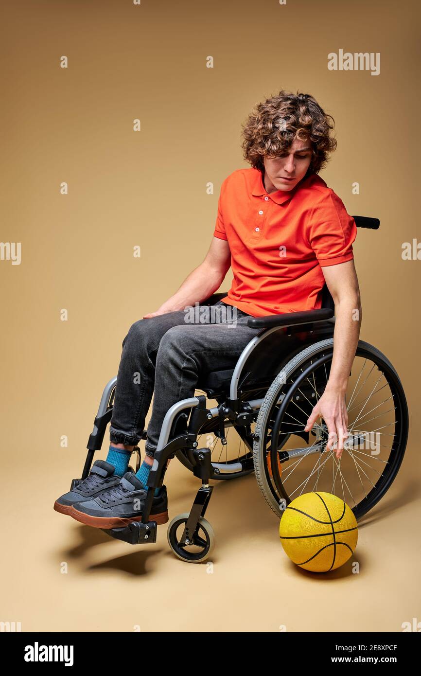 Mann im Rollstuhl in einer einsamen Atmosphäre isoliert, Sportler wollen in basketball.injury engagiert werden, Entmutigung, Verzweiflung Konzept Stockfoto