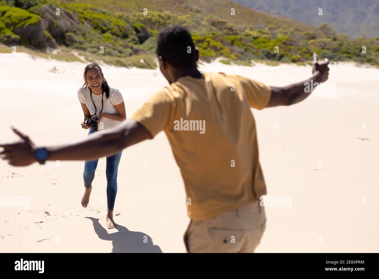 afroamerikanisches Paar, das mit der Kamera am Strand fotografiert Am Meer Stockfoto