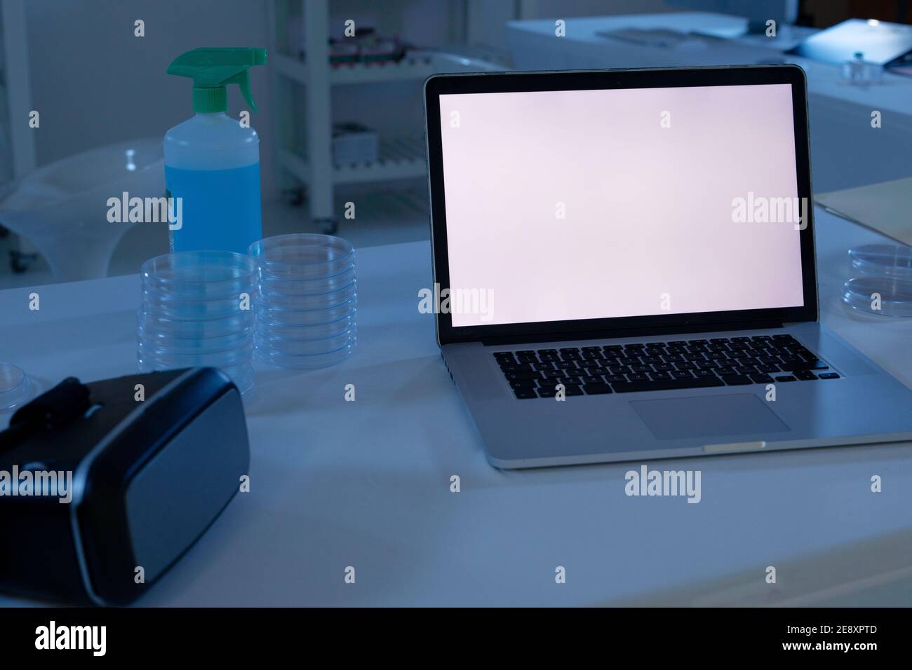 Laptop-Computer mit beleuchtetem Bildschirm am Arbeitsplatz im medizinischen Labor Stockfoto