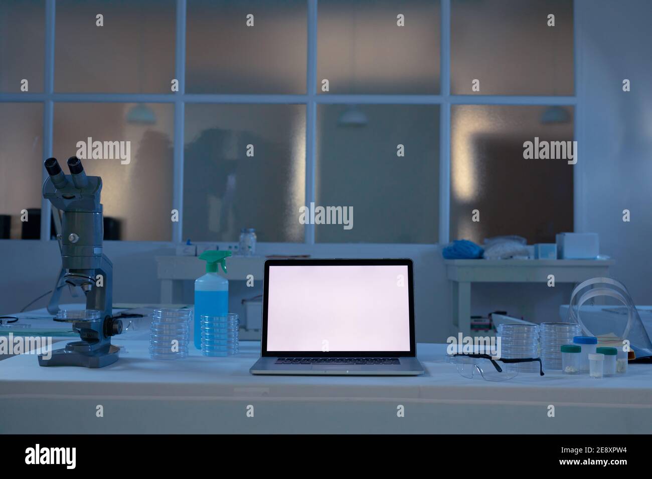 Laptop-Computer mit beleuchtetem Bildschirm am Arbeitsplatz im medizinischen Labor Stockfoto