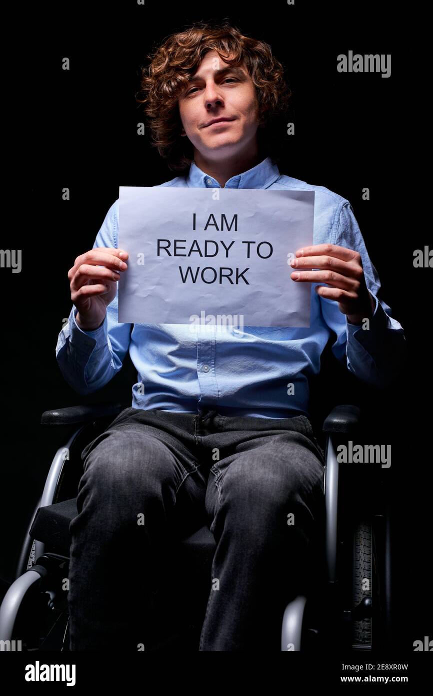 Junge ungültige Mann nicht aufgeben trotz Behinderung, auf der Suche nach Arbeit, bereit, wie jeder arbeiten, isoliert auf schwarzem Hintergrund Stockfoto
