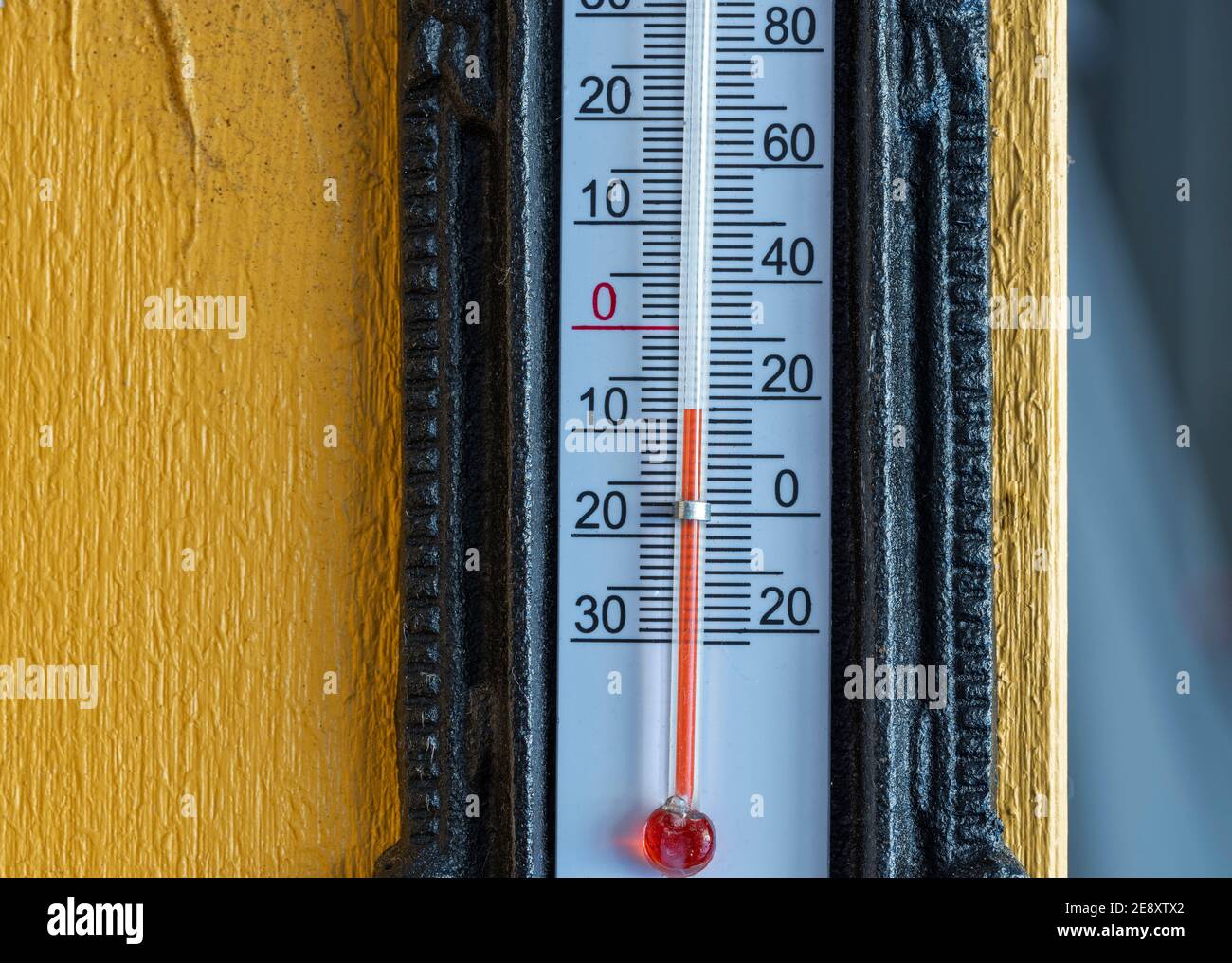 Nahaufnahme des Außenthermometers auf der gelben Holzsäule. Schöne Winterhintergründe. Stockfoto
