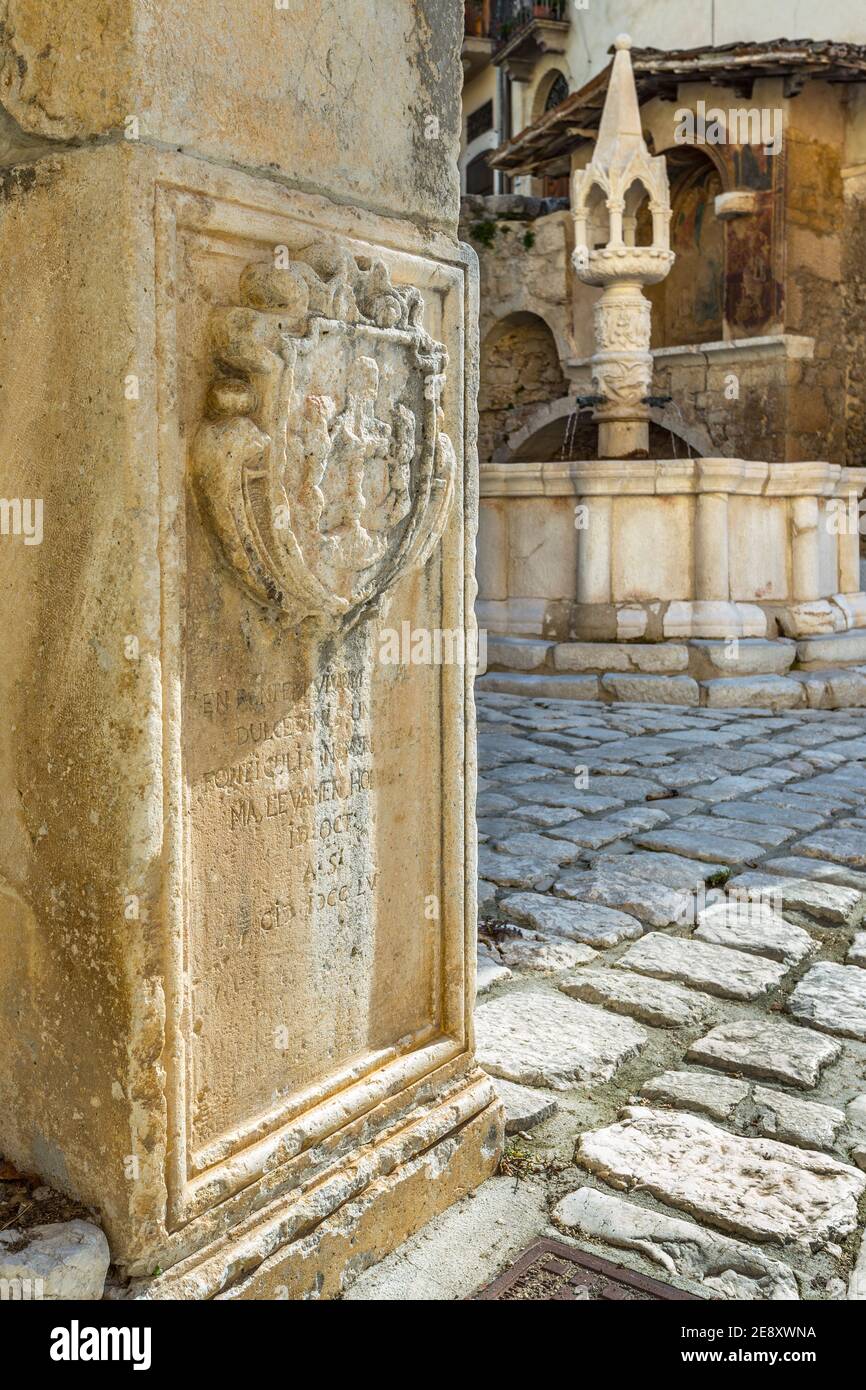 Das Wappen von Fontecchio ist auf dem Stein am Ende der Treppe, die zum mittelalterlichen Platz führt, eingraviert. Fontecchio, Abruzzen, Italien Stockfoto