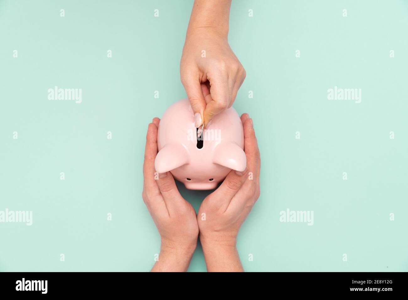 Frau legt eine Münze in ein Sparschwein. Budget, Geld sparen Konzept Stockfoto